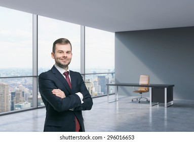 A Handsome Businessman In A Workplace At Modern Corner Panoramic Office In New York, Manhattan. A Concept Of Financial Consulting Services.