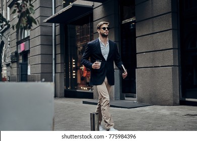 Handsome Businessman. Handsome Young Man In Smart Casual Wear Carrying Disposable Cup While Walking Through The City Street