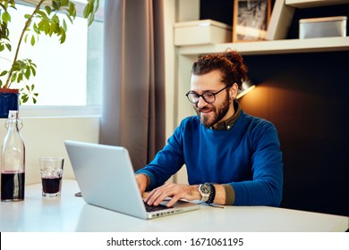 Handsome Caucasian Bearded Businessman Sitting In His Modern Office And Using Laptop For Writing Report.	