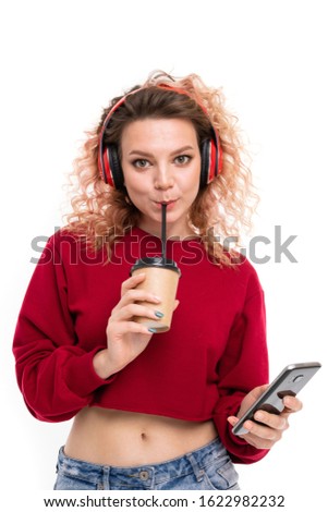 Handsome caucasian female with curly fair hair drinks coffe and smiles