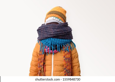 Handsome caucasian funny man hiding face in several hats and scarfs. Winter fashion.