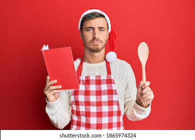 Handsome Caucasian Man Cooking Wearing Baker Apron And Christmas Hat Depressed And Worry For Distress, Crying Angry And Afraid. Sad Expression. 