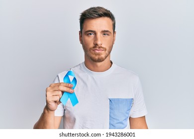 Handsome Caucasian Man Holding Blue Ribbon Thinking Attitude And Sober Expression Looking Self Confident 
