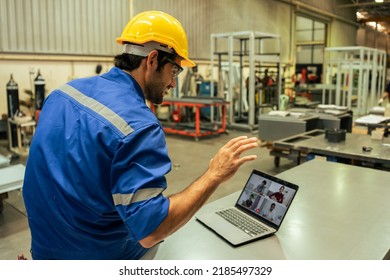 Handsome Caucasian Man Industry Worker Working In Factory Warehouse. Attractive Male Industrial Engineer Using Laptop For Meeting And Processes Orders And Products For Customer At Manufacturing Plant.