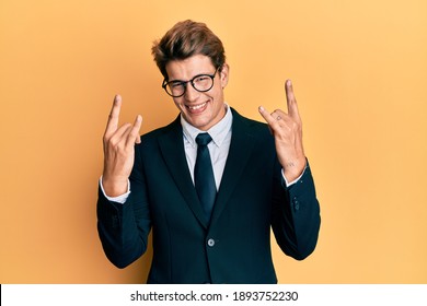 Handsome Caucasian Man Wearing Business Suit And Tie Shouting With Crazy Expression Doing Rock Symbol With Hands Up. Music Star. Heavy Concept. 