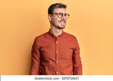 Handsome Caucasian Man Wearing Casual Clothes And Glasses Looking To Side, Relax Profile Pose With Natural Face And Confident Smile. 