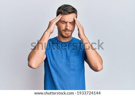 Handsome caucasian man wearing casual clothes with hand on head, headache because stress. suffering migraine. 