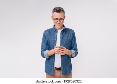 Handsome caucasian mature man in casual clothes using mobile phone isolated over white background