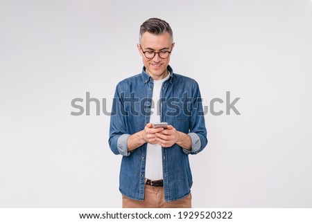 Handsome caucasian mature man in casual clothes using mobile phone isolated over white background