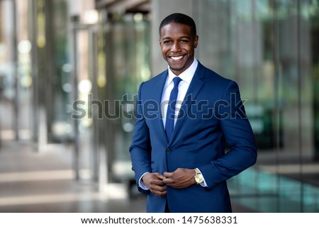 Handsome charming cheerful african american businessman in swanky modern stylish suit and tie, colorful, classy, office building