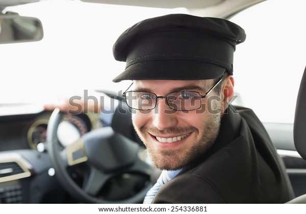 Handsome chauffeur\
smiling at camera in the\
car