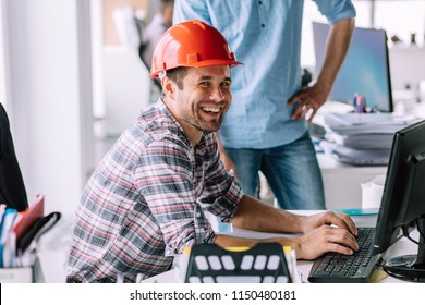 Handsome Cheerful Engineer Is Having Fun In Front Of The Computer At Work. Happiness Concept