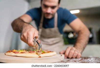 handsome chef cut delicious homemade italian mozzarella pizza after prepare and bake from stove or oven for lunch meal or dinner in local italian pizza restaurant - Powered by Shutterstock