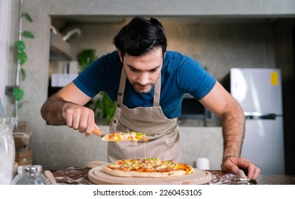 handsome chef cut delicious homemade italian mozzarella pizza after prepare and bake from stove or oven for lunch meal or dinner in local italian pizza restaurant - Powered by Shutterstock