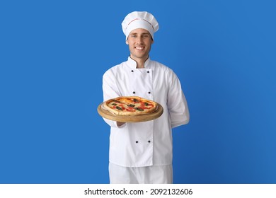 Handsome chef with delicious pizza on blue background - Powered by Shutterstock