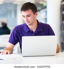 Handsome College Student Using His Laptop Computer In The Campus Common Area/high School Study Room, Absorbed (shallow DOF; Color Toned Image)