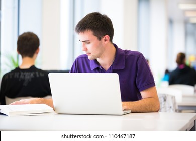 Handsome College Student Using His Laptop Computer In The Campus Common Area/high School Study Room, Absorbed (shallow DOF; Color Toned Image)