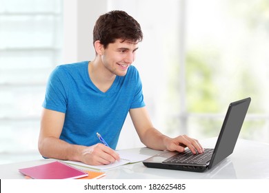 Handsome College Student Using His Laptop Computer In The Campus