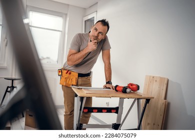 Handsome concentrated craftsman carefully planning construction