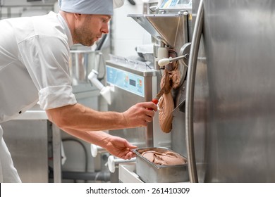 Handsome confectioner in chef uniform producing ice cream with ice cream machine