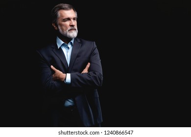 Handsome confident mature business man isolated on black background