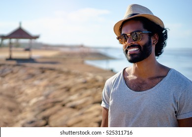 Handsome and confident. Outdoor portrait of smiling young african man on the beach.