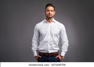 A Handsome Confident Young Man Standing Seriously In A White Shirt.
