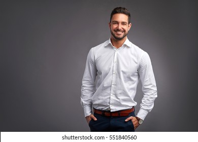 A Handsome Confident Young Man Standing And Smiling In A White Shirt.
