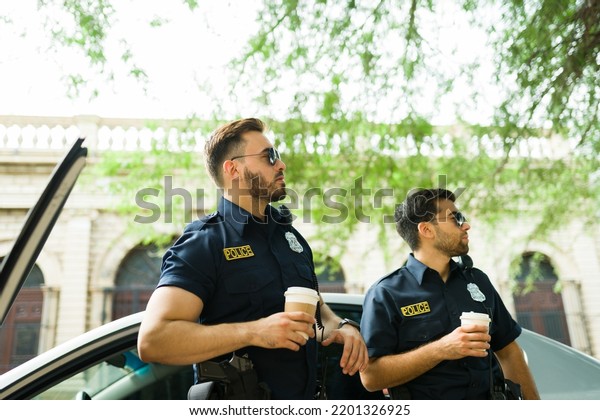 Handsome cop agents getting out of the police car\
to get some coffee while on\
duty