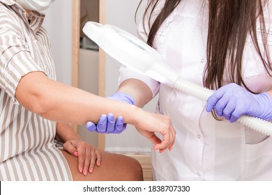 A handsome cosmetologist with long dark hair is performing an electrolysis procedure. In the beautician's office. Close-up.