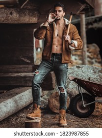 Handsome Countryside Male Model Smoking A Cigar And Cutting Wood In His Farm In Stockholm Sweden