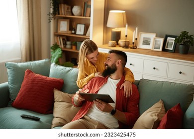 Handsome couple relaxing at home and looking at tablet - Powered by Shutterstock