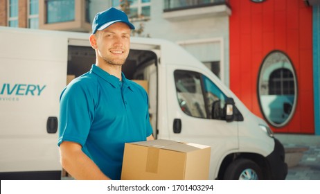 Handsome Courier Takes Cardboard Box Package out of Delivery Van Walks Through Modern Stylish Business District. Courier On the Way to Deliver Postal Parcel to a Client