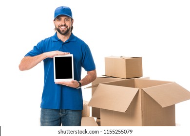 handsome delivery man holding digital tablet with blank screen and smiling at camera isolated on white
