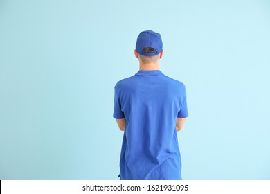 Handsome Delivery Man On Color Background, Back View