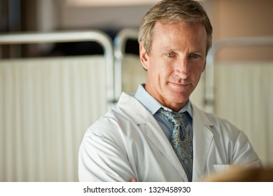 Handsome Doctor With A Good Bedside Manner Listening To His Patient.