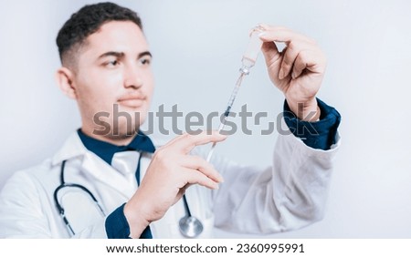 Handsome doctor holding syringe with antidote on isolated background. Closeup of doctor holding syringe and antidote isolated