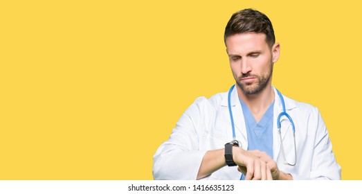 Handsome Doctor Man Wearing Medical Uniform Over Isolated Background Checking The Time On Wrist Watch, Relaxed And Confident