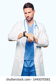 Handsome Doctor Man Wearing Medical Uniform Over Isolated Background Checking The Time On Wrist Watch, Relaxed And Confident