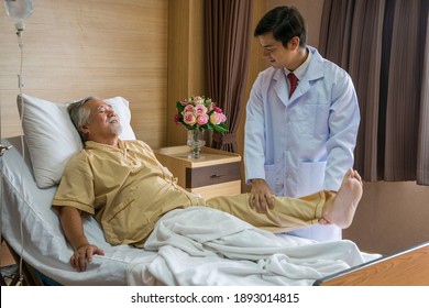 The handsome doctor is a physical therapist, taking care of the elderly patients' legs at the hospital.