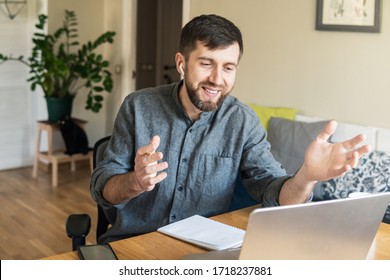 Handsome Eastern European Man Working From Home During Corona Virus Quarantine Lockdown, Having Online Video Chat With His Colleagues