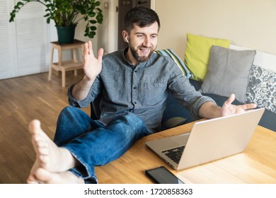 Handsome Eastern European Man Working From Home During Corona Virus Quarantine Lockdown, Having Online Video Chat With His Colleagues