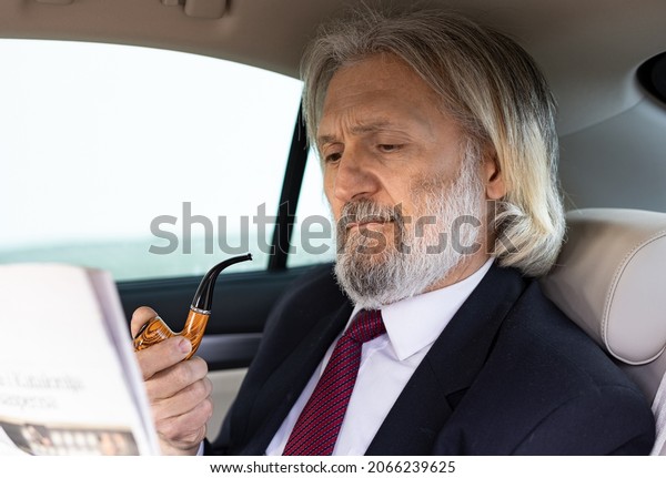 A handsome\
elderly businessman is in the\
car