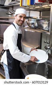 Handsome Employee Doing Dishes In Commercial Kitchen