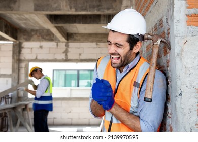 Handsome Engineer Man Injured His Wrist When He Using Hammer Hit On A Nail While Repair A House Project. Concept Of Occupational Safety And Occupational Accident Insurance