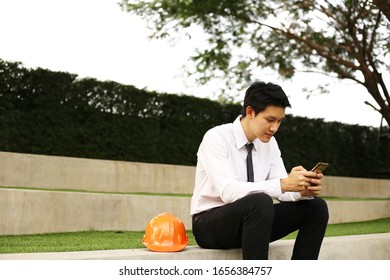 Handsome engineer man using mobile  in the park 