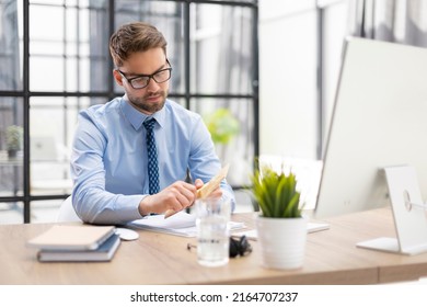 Handsome Entrepreneur Opening A Padded Envelope In A Desktop At Office.