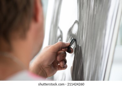 Handsome fair-haired painter drawing his wonderful picture with the charcoal