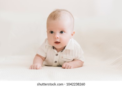 Handsome fashionable little boy lying on a blanket, with a sweet expression - Powered by Shutterstock