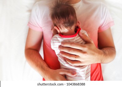 Handsome father holding his sleeping newborn baby daughter. Close up - Powered by Shutterstock